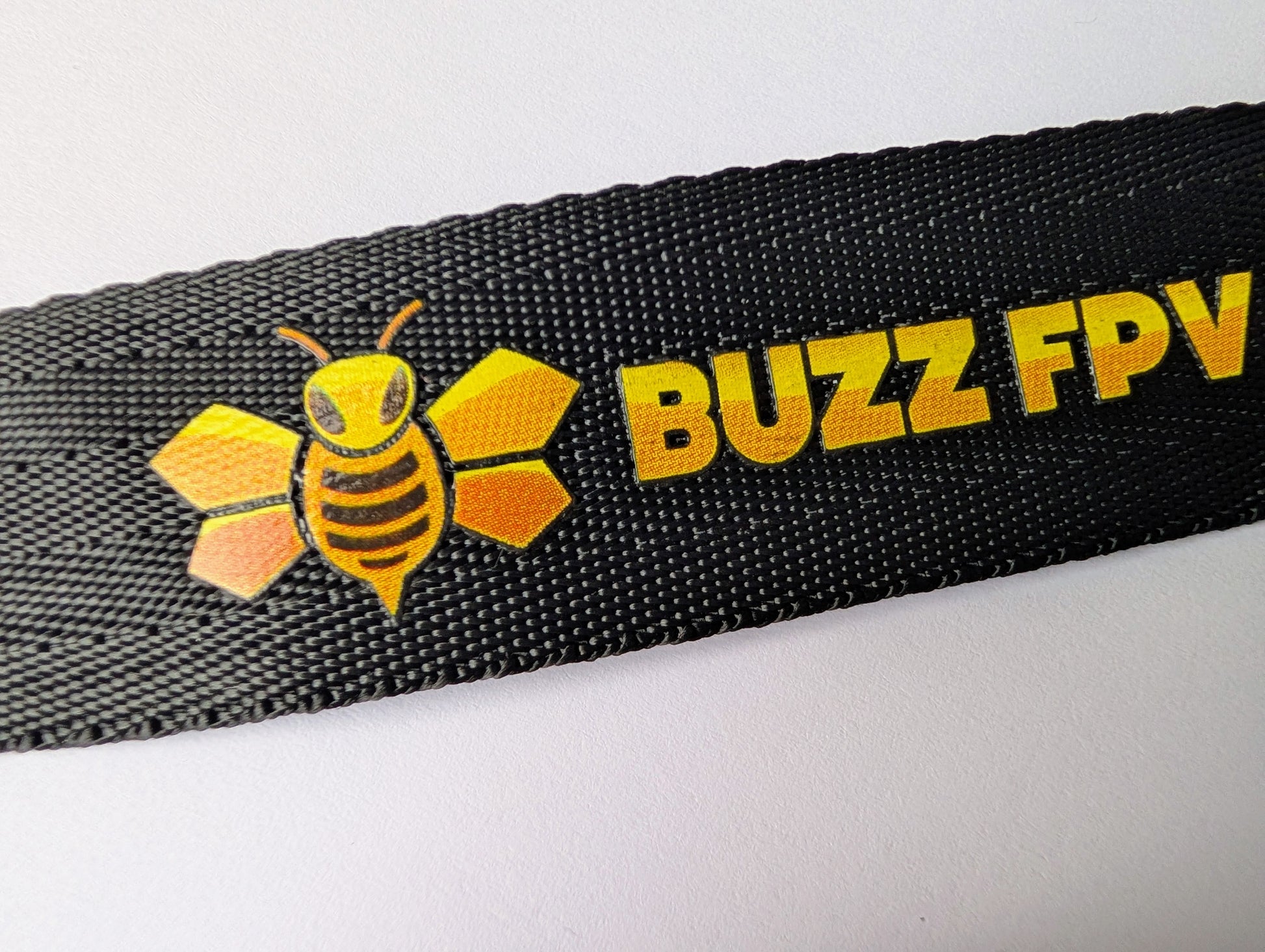 Black strap with Buzz FPV logo featuring a bee design on a white background